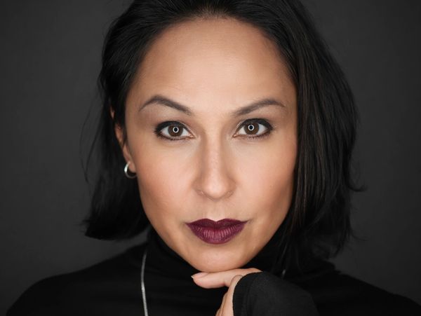Close-up portrait of a woman with dark hair and bold lipstick.