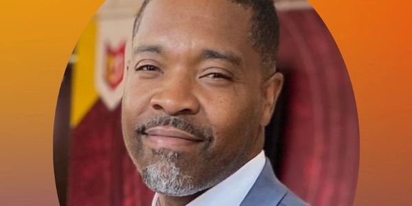 Man in a suit smiling.