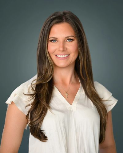 Woman with long brown hair smiling.