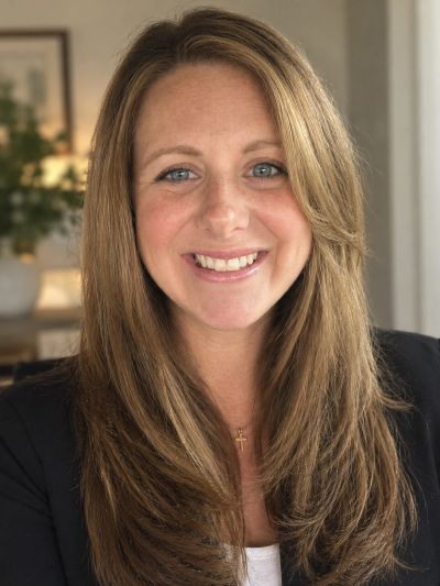 Smiling woman with long blond hair and blue eyes.