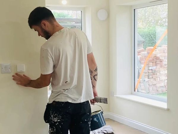 Decorator painting an interior wall in this modern living space 