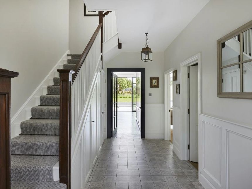 Bright hallway with painted walls, white woodwork, staircase  and clean interior decorating finish.