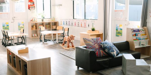 Bright and organized early childhood classroom with toys and seating areas.