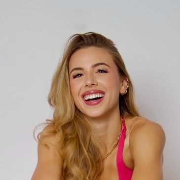 Smiling woman with long blonde hair and a pink top.