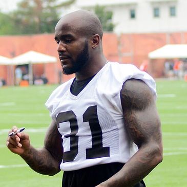 Muscular football player signing autograph outdoors.