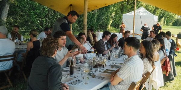 Outdoor dining event under a yellow canopy.