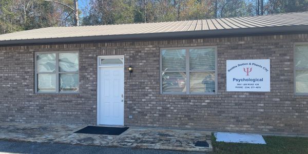 Brick building with a white door and a psychology clinic sign.