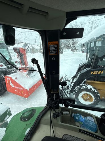 View from inside a tractor cab during snow clearing.