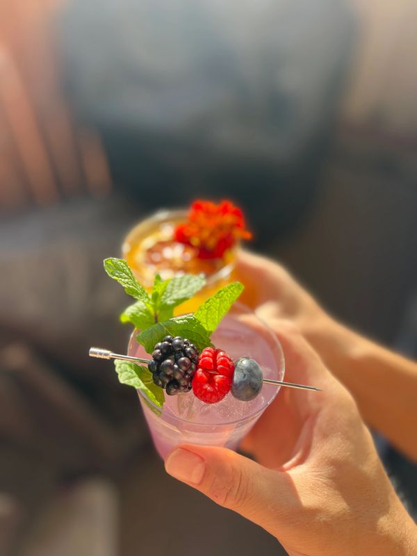 Overhead view of colorful signature cocktails with fruit and floral garnishes served in Irvine CA