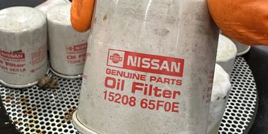 Close-up of a Nissan genuine oil filter with part number 15208 65F0E.