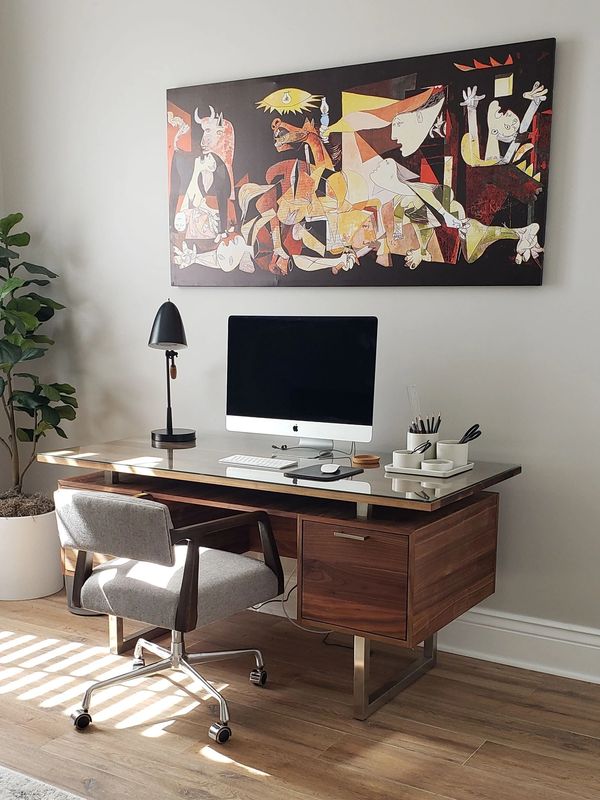 Minimalist home office with wooden desk and modern chair.