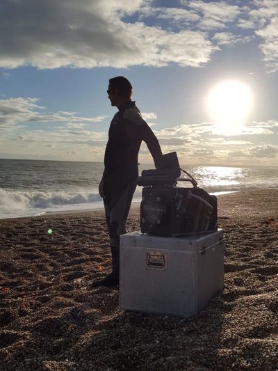 man on the seaside with cinematography tools