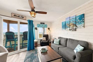 Cozy living room with ocean view balcony.