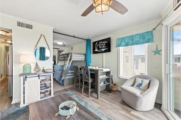 Cozy beach-themed bunk room with ocean decor.