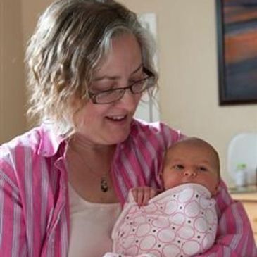 Woman holding a swaddled baby.