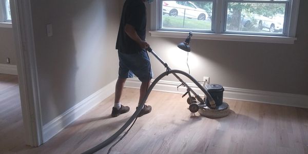 Person cleaning hardwood floor with machine.