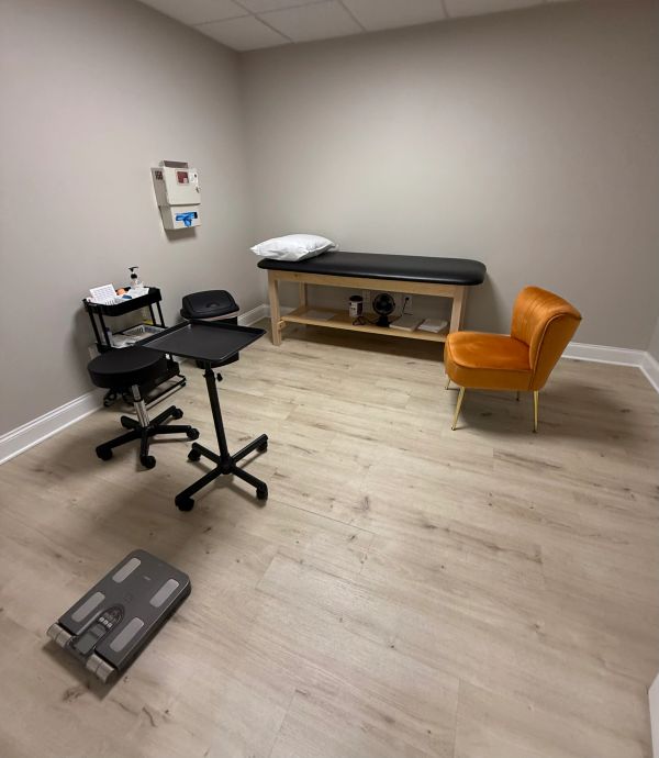 A clean medical examination room with minimal furniture.