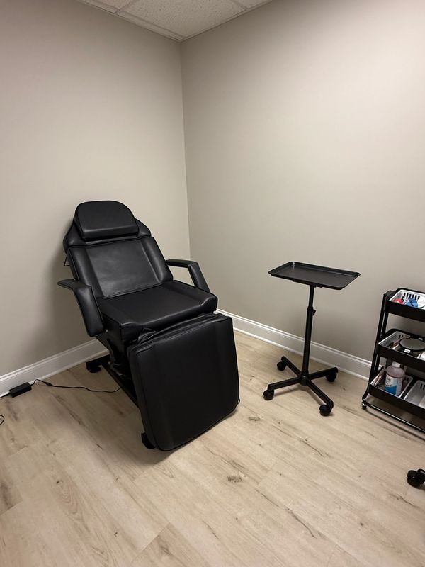 Black chair and small table in a simple room.