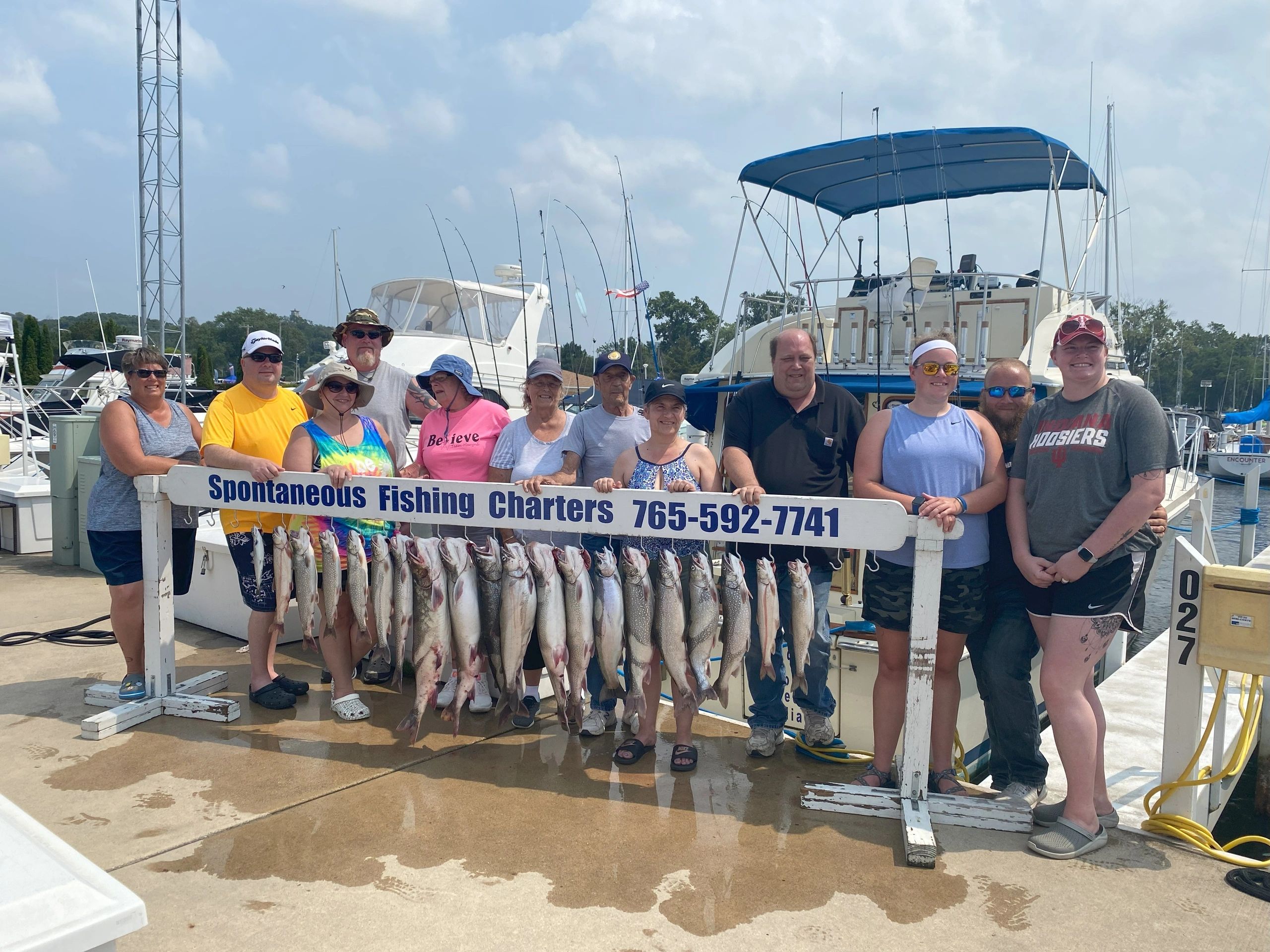 Group of people with their fishing catch at a marina.
