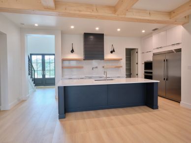Modern kitchen with black island and stainless steel appliances.