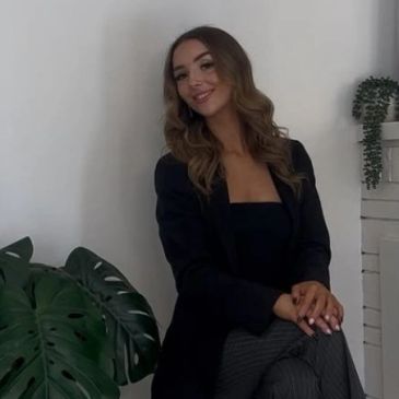 Woman with wavy hair smiling indoors.