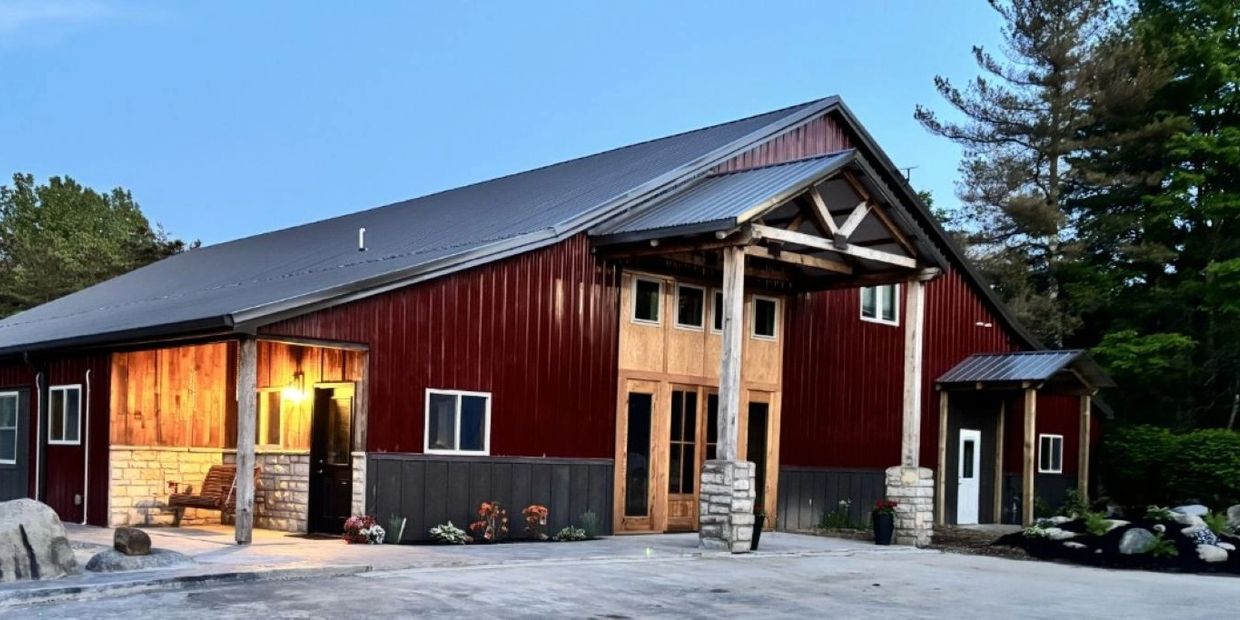 Rustic barn-style building with wooden and stone accents under a clear blue sky.