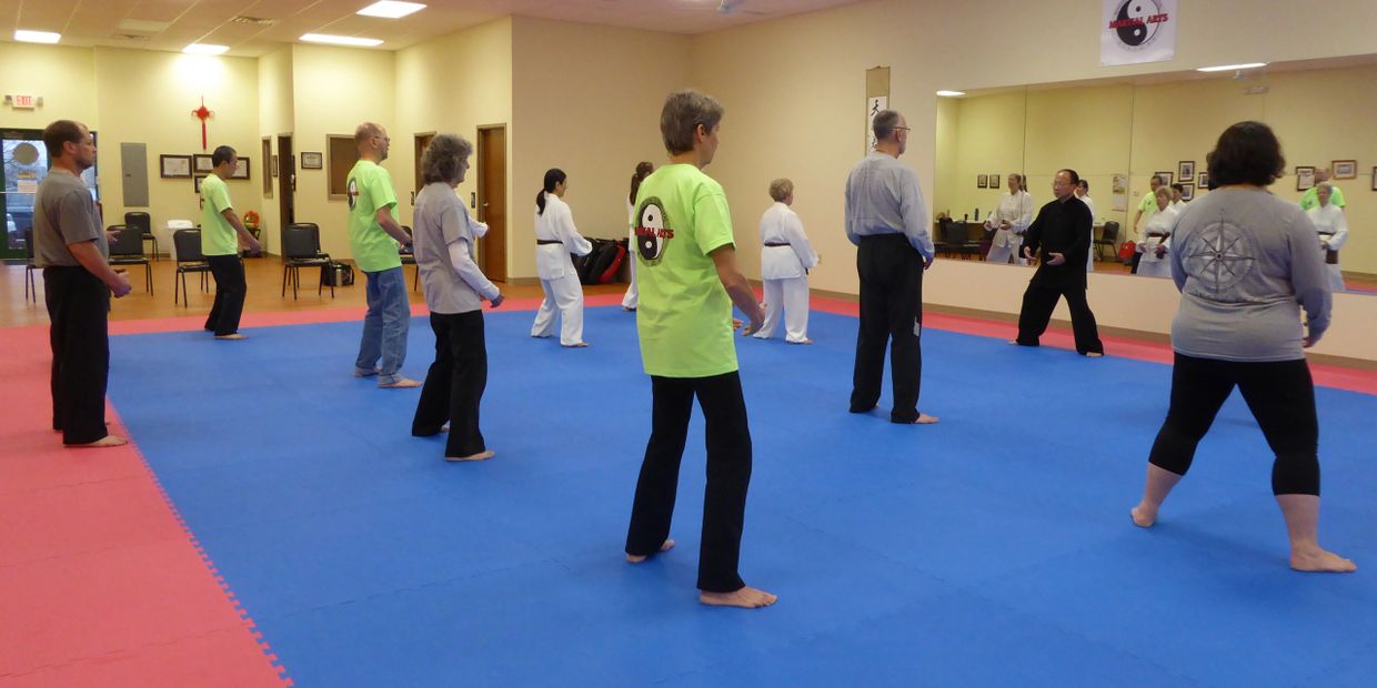 Tai Chi for Health students stand and meditate with instructor.  Tai chi studio with class practicing standing meditation (zhan zhuang) with Master Ling.