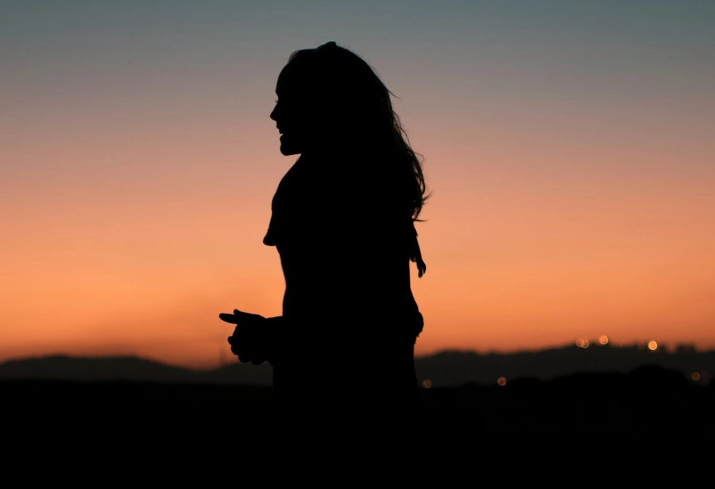 A WOMAN WHO IS AN IT CONSULTANT IN AGAINST A BACKDROP OF SUNSET 