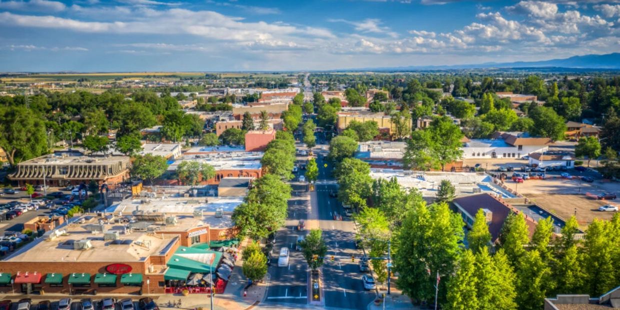 A vibrant town with tree-lined streets and clear blue skies.