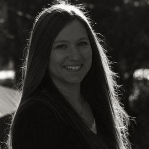 Black and white portrait of a woman smiling with long hair.