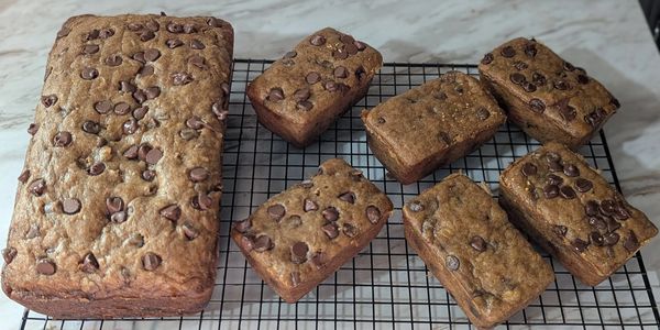 Freshly baked chocolate chip banana bread cooling on a wire rack.