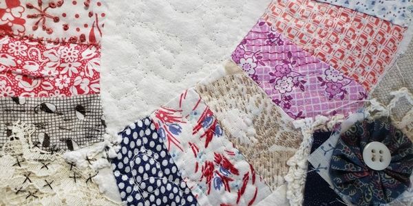 old wedding ring quilt top piece with new hand-stitching and embelishmnts