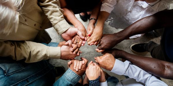 Image of a group of people in a circle holding hands