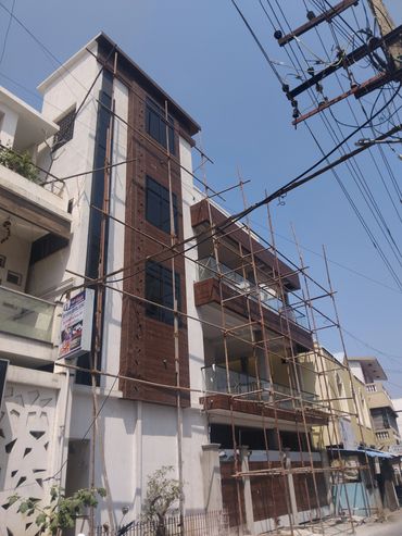Multi-story building under construction with bamboo scaffolding.