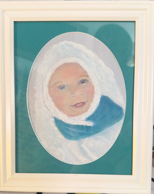 Framed pastel portrait of a baby wrapped in a white blanket with a blue scarf.