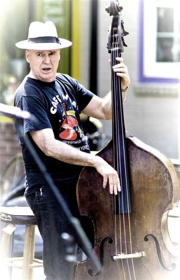 Man playing upright bass outdoors.