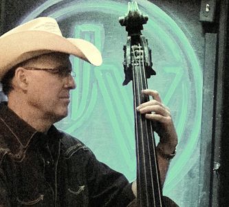 Man playing upright bass wearing a cowboy hat.