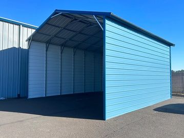 Blue metal carport with three walls on a sunny day.