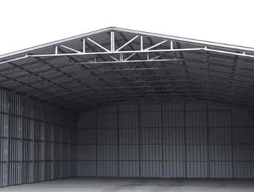 Empty metal storage shed with concrete floor.