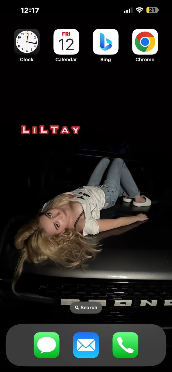 LiLTay laying down on a truck hood white tee and blue jeans home screen wallpaper