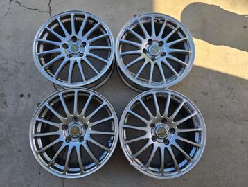 Set of four silver alloy car rims with multiple spokes.