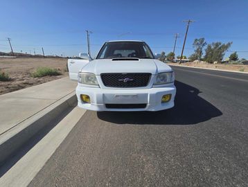 White SUV parked on a sunny roadside with one door open.