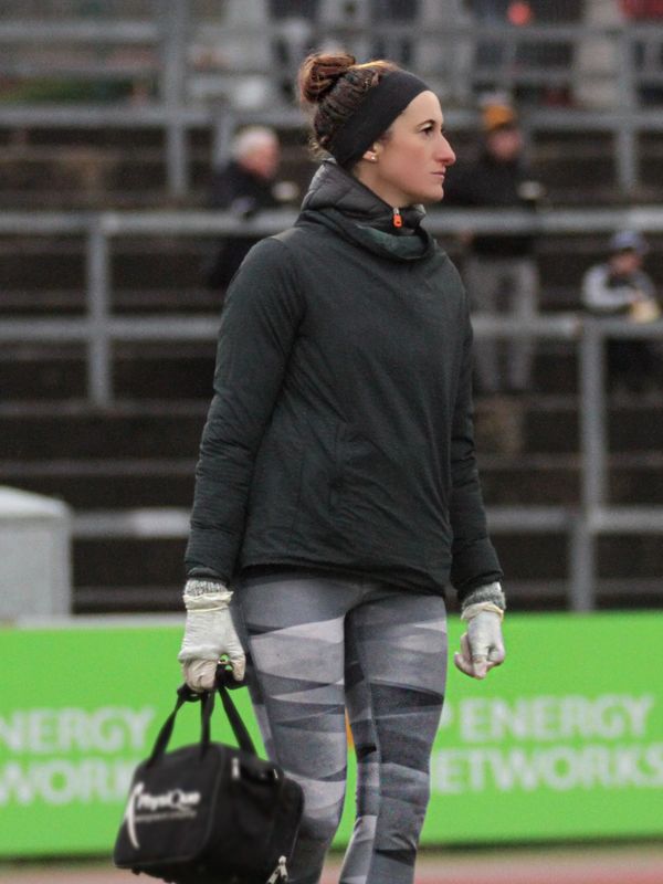 Woman dressed for cold weather, holding a black bag.