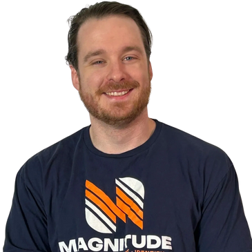 Smiling man wearing a navy blue Magnitude t-shirt.