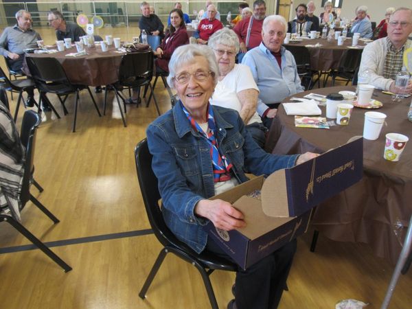 Jan Handel smiles with Volunteer of the Year prize from Great Harvest as other volunteers look on