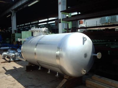 A large, shiny metal industrial tank in a workshop.