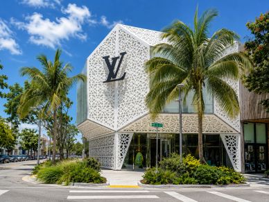 Louis Vuitton store with modern design and palm trees.