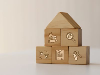 Wooden blocks forming a house with real estate icons.