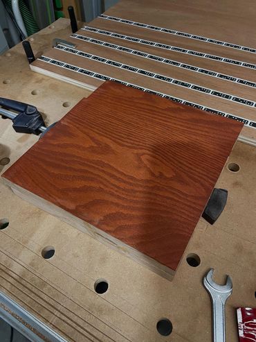 A stained piece of wood on a workbench 