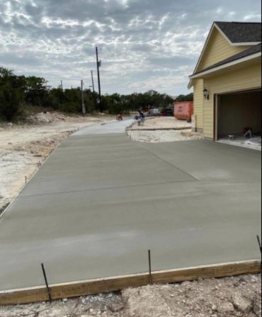 Best concrete contractors in Boerne finishing a concrete driveway.